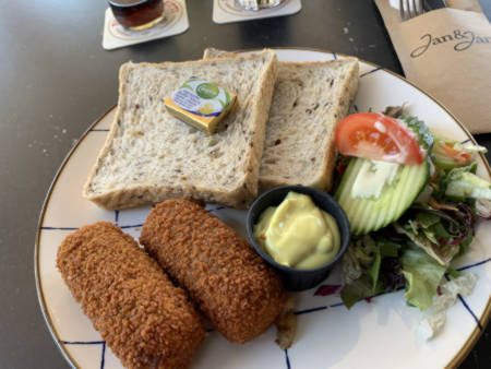 Kroketten mit Weißbrot und Salat, Butter und einer Soße.