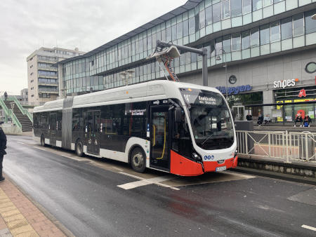 Kölner Verkehrsbetriebe Buslinie 141 beim Aufladen des Elektrobusses gegenüber einem Einkaufszentrum.