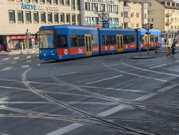 Kassel,blaue Straßenbahn mit gelben Türen am zentralen Knotenpunkt "Am Stern" in der Innenstadt an einem sonnigen Abschnitt. 