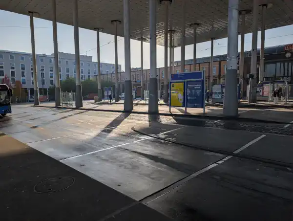 Kassel Wilhelmshöhe im Hintergrund das Bahnhofsgebäude, im Vordergrund die Straßenbahn und Busumsteigemöglichkeiten